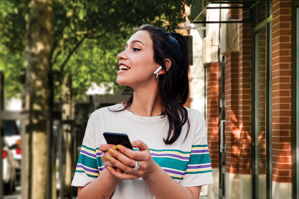 young woman walking while listening to music